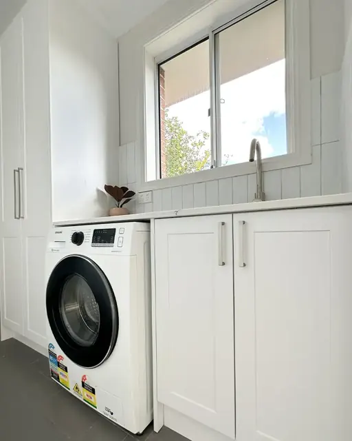Laundry cabinetry with bench space and appliance storage